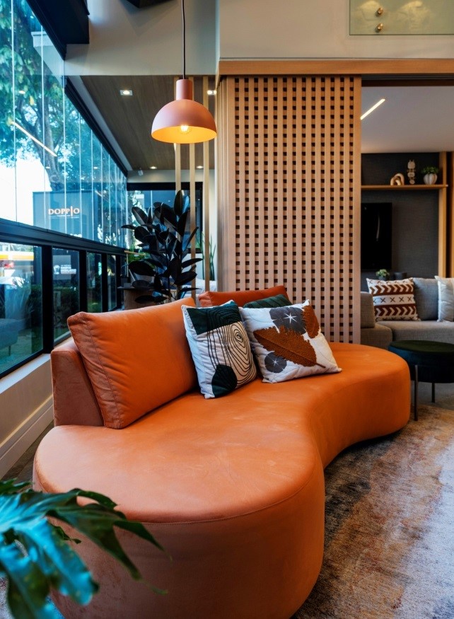Tendências: Sofá curvo na cor laranja e estampas de folhagens nas almofadas roubam a cena no projeto da arquiteta Natalia Guesso | Foto: Emerson Rodrigues
